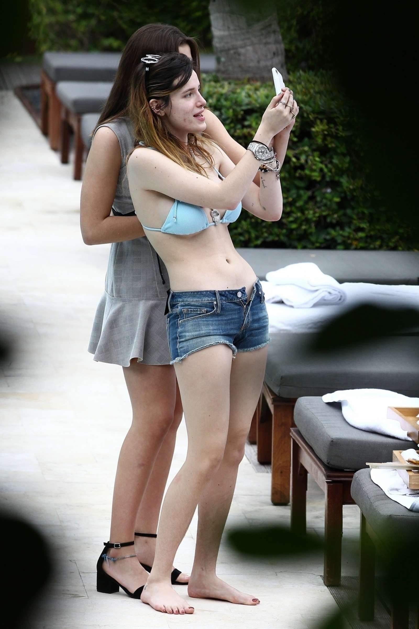 Bella Thorne in Bikini Top and Shorts at the pool in Miami