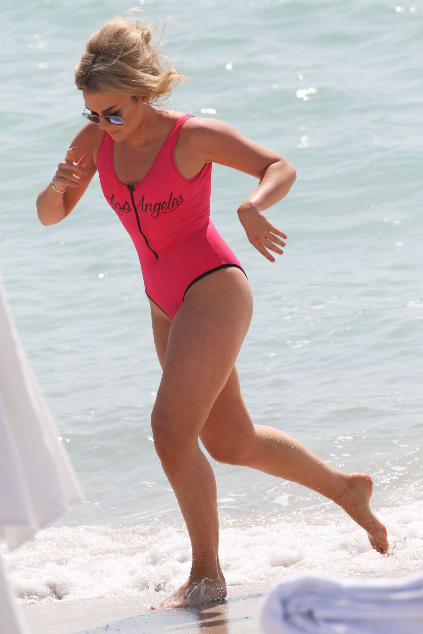 Tallia Storm in Neon Pink Swimsuit on the beach at Cannes