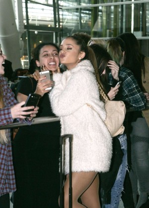 Ariana Grande Shows Legs in a fur coat at Heathrow Airport in London