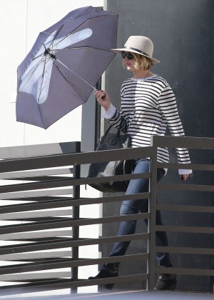 Jennifer Lawrence in Jeans and Umbrella Leaving an office building in LA