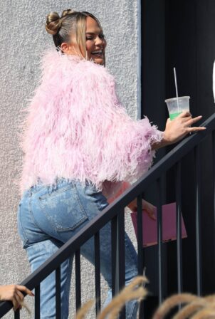 Chrissy Teigen - In a pink feathered sweater and blue jeans out in Los Angeles