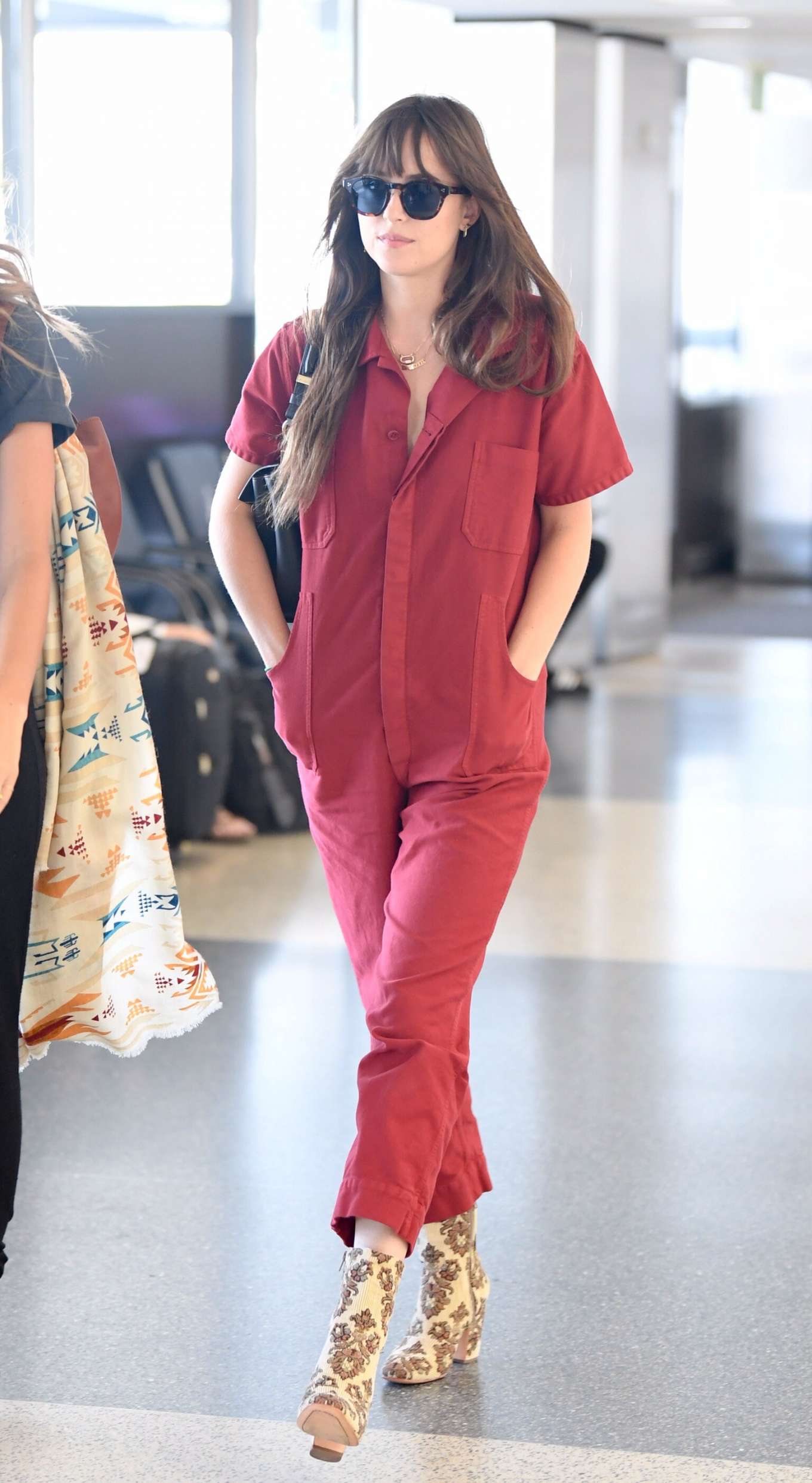 Dakota Johnson in Red Jumpsuit - Arrives at Los Angeles International Airport
