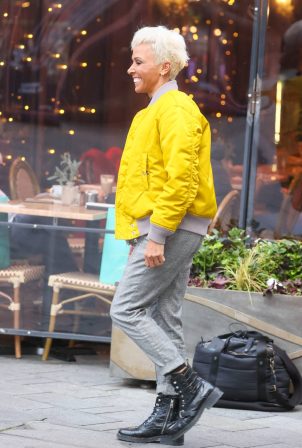 Dame Kelly Holmes - Wearing yellow bomber jacket and blond hair in London