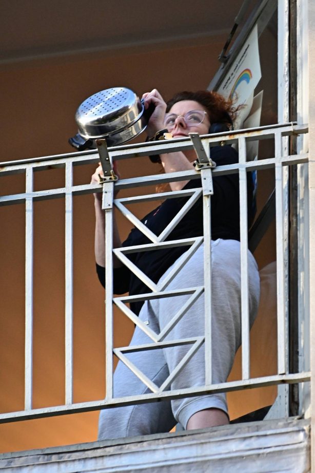 Debra Messing - Sports headphones while cheering for first responders on her NYC Balcony