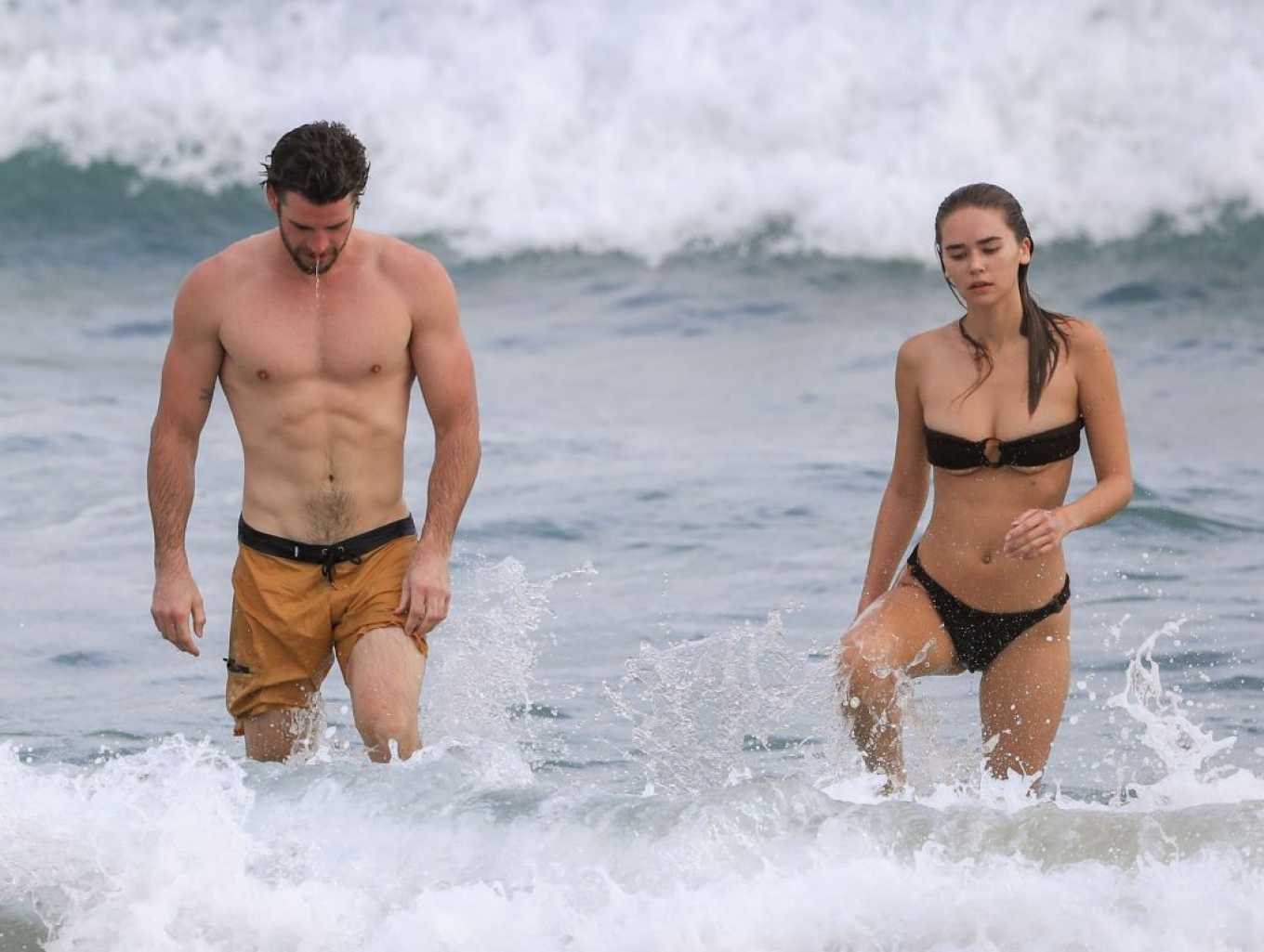 Gabriella Brooks in Black Bikini and Liam Hemsworth on the beach in Byron Bay