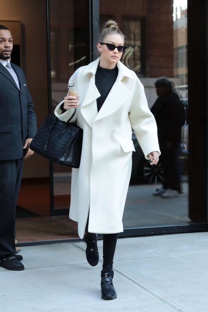 Gigi Hadid in white coat leaving her home in NYC