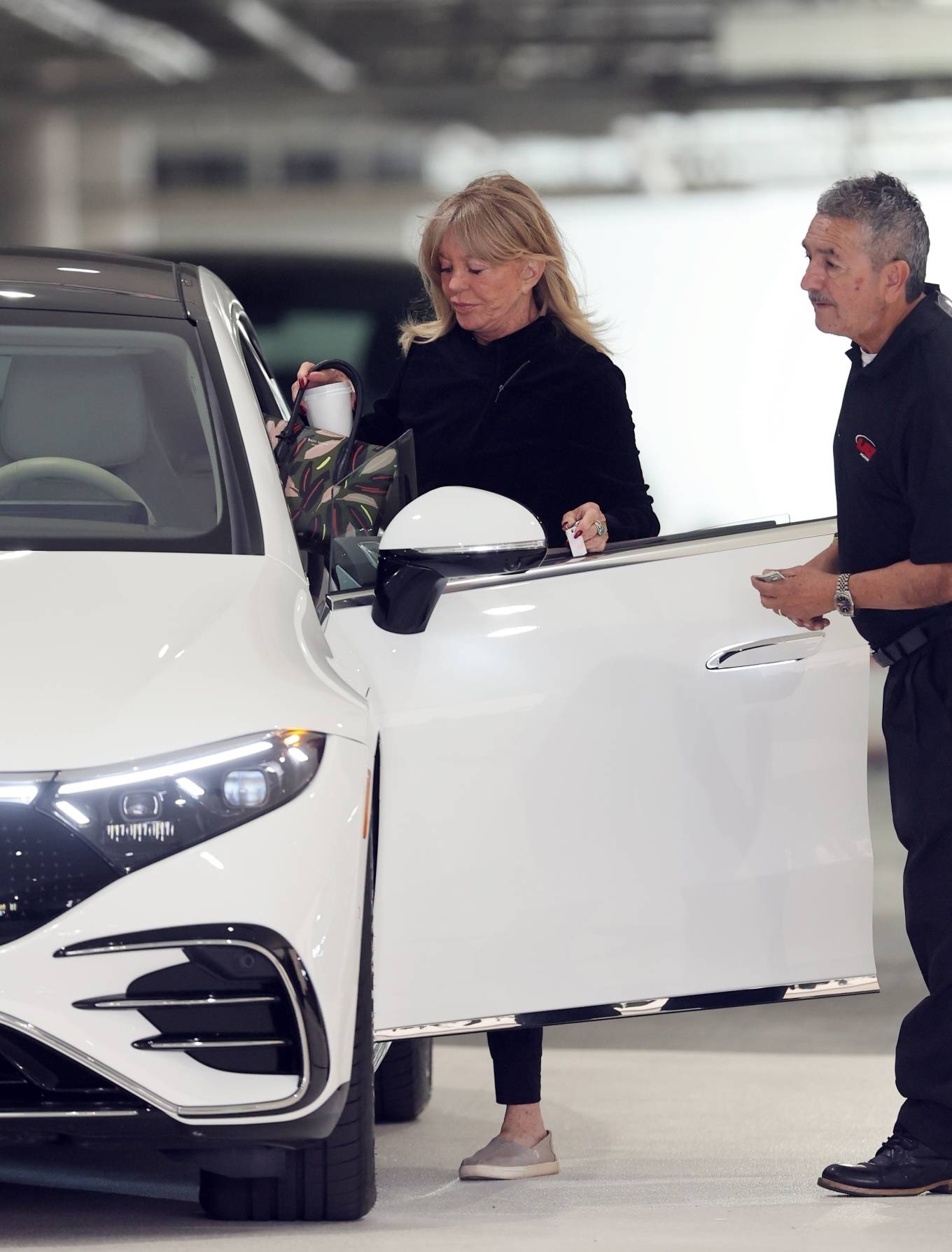 Goldie Hawn - Getting into her new white Electric Mercedes Benz in Santa Monica