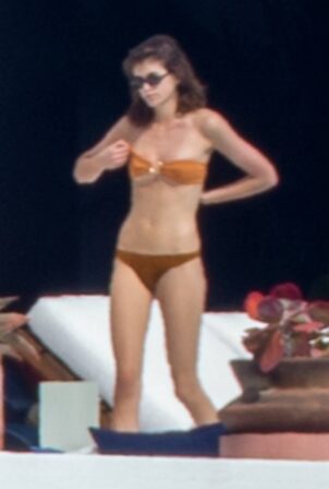 Kaia Gerber - In a orange bikini poolside candids in Los Cabos