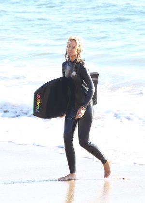 Lady Victoria Hervey in a wetsuit surfing on Malibu Beach