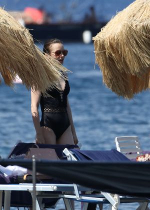 Lily Collins in Black Swimsuit at a beach in Ischia