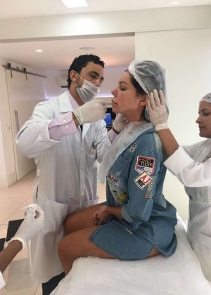 Liziane Gutierrez squirms as she gets implants in Rio de Janeiro