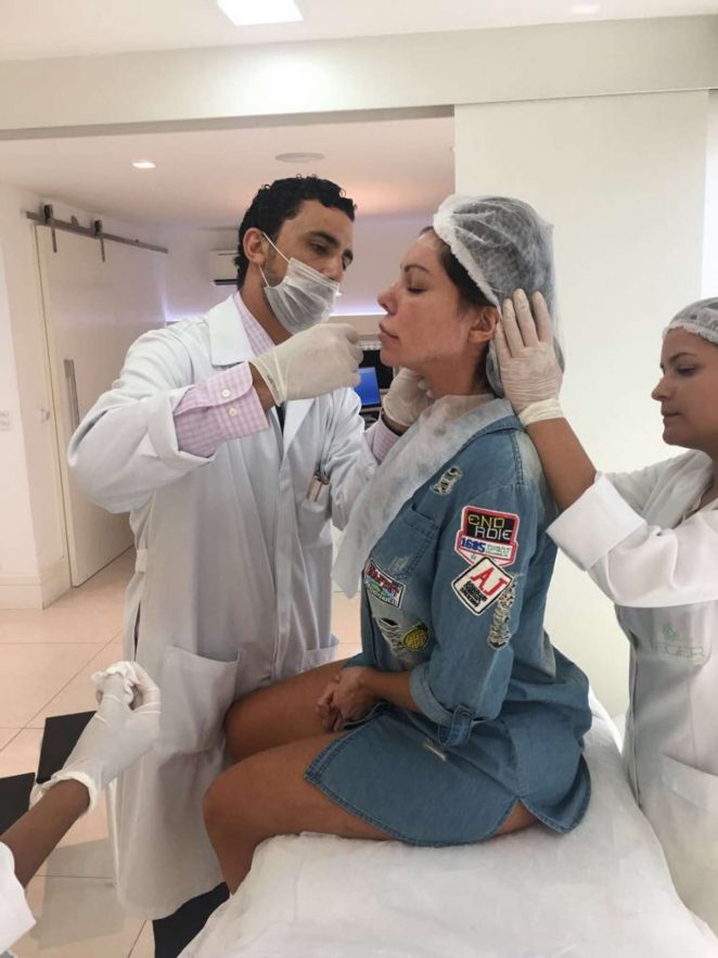 Liziane Gutierrez squirms as she gets implants in Rio de Janeiro