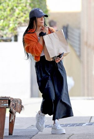 Tessa Thompson - Seen wearing an orange Cardigan and New York Cap with platform trainers